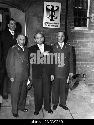 West German Defence Minister, Theodor Blank, stands under the German Eagle flanked by Lieutenant Generals Adolf Heusinger, left, and Hans Speidel after handing them their call-up papers in Bonn, Germany on Nov. 12, 1955. Blank handed call-up papers to the first 101 volunteers for the new 500,000 men Wehrmacht (German Army). (AP Photo)