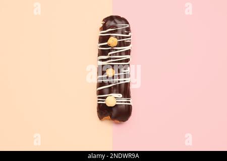 Tasty chocolate eclair on yellow and pink background Stock Photo