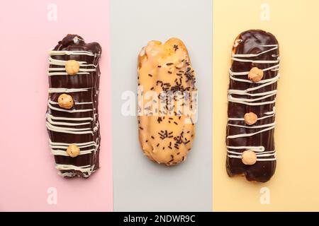 Tasty glazed eclairs on colorful background Stock Photo