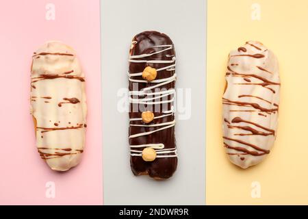 Tasty glazed eclairs on colorful background Stock Photo