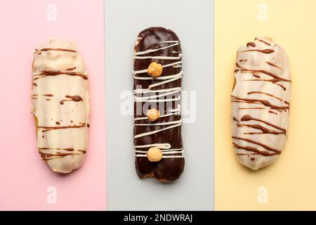 Tasty glazed eclairs on colorful background Stock Photo