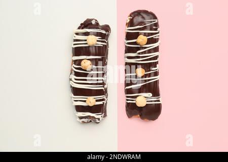Tasty chocolate eclairs on grey and pink background Stock Photo