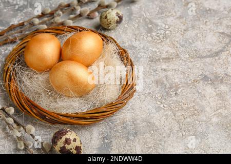 Wreath with Easter eggs and willow branches on grunge background, closeup Stock Photo