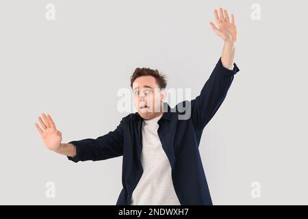 Scared young man on light background Stock Photo