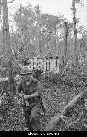 Paratroopers of B Company, 173rd airborne brigade move in file through jungle near long cat in Vietnam on August 1, 1965 in search of communist Viet Cong guerrillas. Air force B52 bombers struck the area, 35 miles from Saigon in support of the paratroops, that began a search and destroy operation. The fourth day of the operation, paratroopers did not make contract with any Viet Cong—dead or alive. (AP Photo)