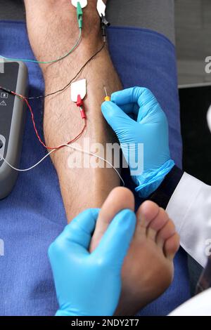 Electromyography in the lower limbs, graphic recording technique of the electrical activity produced by the tibial muscle performed by a specialist ne Stock Photo