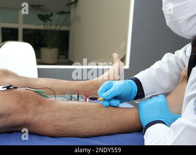 Electromyography in the lower limbs, graphic recording technique of the electrical activity produced by the tibial muscle performed by a specialist ne Stock Photo