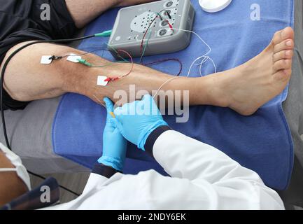 Electromyography in the lower limbs, graphic recording technique of the electrical activity produced by the tibial muscle performed by a specialist ne Stock Photo