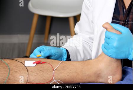 Electromyography in the lower limbs, graphic recording technique of the electrical activity produced by the tibial muscle performed by a specialist ne Stock Photo