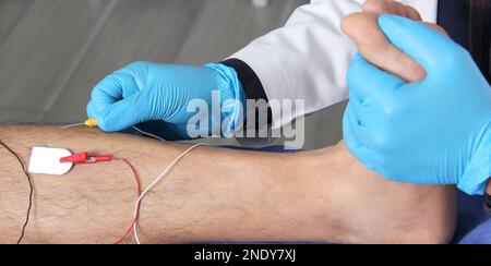 Electromyography in the lower limbs, graphic recording technique of the electrical activity produced by the tibial muscle performed by a specialist ne Stock Photo