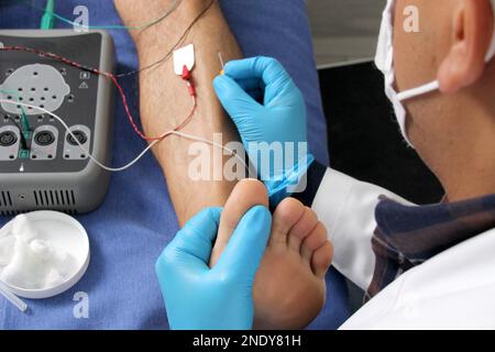 Electromyography in the lower limbs, graphic recording technique of the electrical activity produced by the tibial muscle performed by a specialist ne Stock Photo