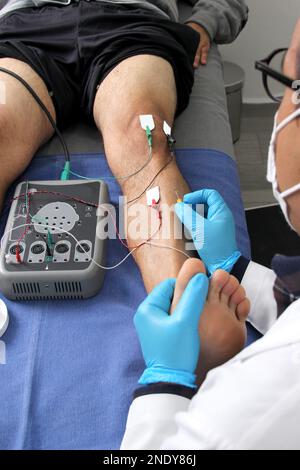 Electromyography in the lower limbs, graphic recording technique of the electrical activity produced by the tibial muscle performed by a specialist ne Stock Photo