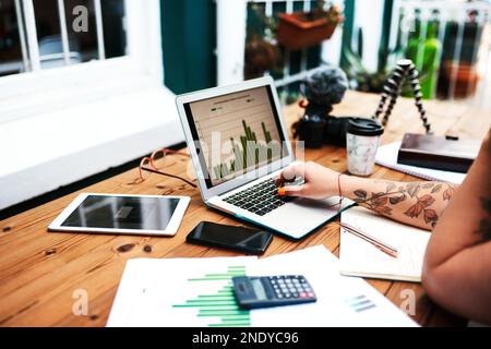 Making sure the data is right. an unrecognizable businesswoman sitting alone at her desk and using her laptop. Stock Photo