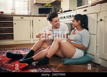 Its time for coffee and catchup. a young couple having coffee in their kitchen at home. Stock Photo