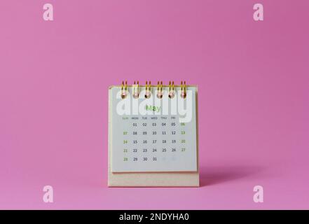 Desktop calendar for May 2023 on a pink background Stock Photo