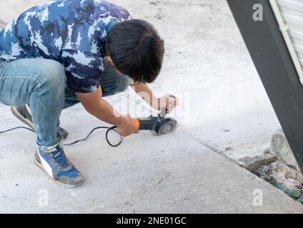 Worker use stone grinding machine cut floor for tube embeded. Stock Photo