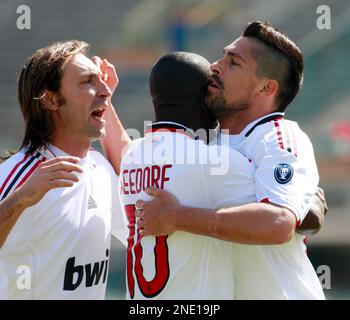 AC Milan s Marco Borriello right is hugged by teammates Clarence