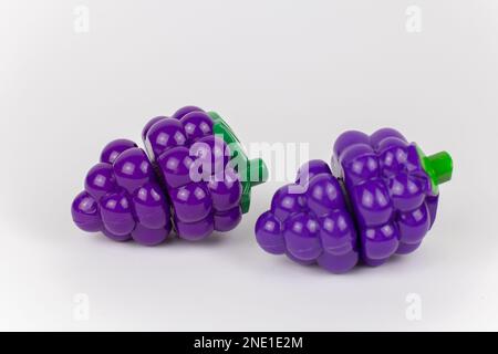 a plastic toy grapes on a white background Stock Photo