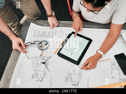 We have everything done except for here...High angle shot of two unrecognizable architects using a digital tablet while working together in a modern Stock Photo