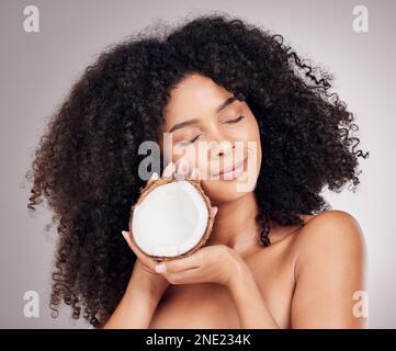 Coconut, beauty and black woman isolated on studio background for natural skincare, face and hair dream. Afro model or young person sleeping with Stock Photo