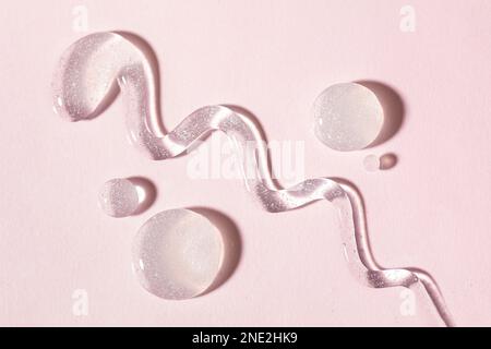 Cosmetic lotion transparent gel drops texture background, pink Stock Photo