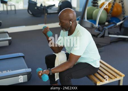 African american senior man working out with dumbbells at the gym. retirement senior lifestyle and living concept Stock Photo
