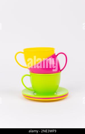 a multi-colored plastic cups and plates on a white background kitchen set Stock Photo