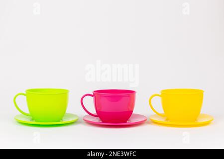 a multi-colored plastic cups and plates on a white background kitchen set Stock Photo
