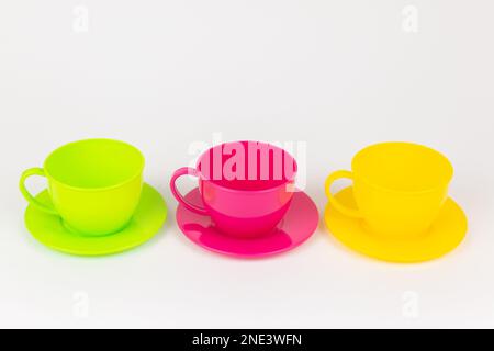 a multi-colored plastic cups and plates on a white background kitchen set Stock Photo