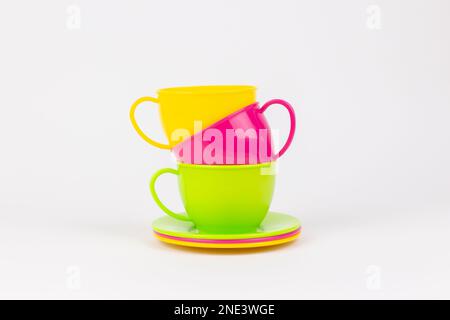 a multi-colored plastic cups and plates on a white background kitchen set Stock Photo
