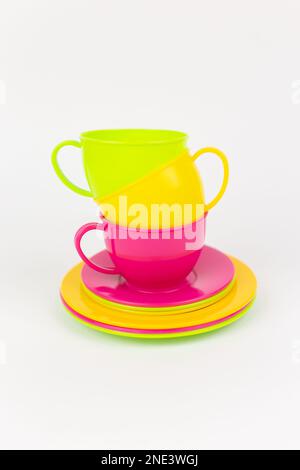 a multi-colored plastic cups and plates on a white background kitchen set Stock Photo
