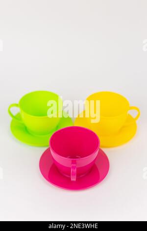 a multi-colored plastic cups and plates on a white background kitchen set Stock Photo
