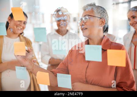Senior, business meeting or CEO writing a marketing strategy, advertising plan or branding ideas. Sticky notes, pregnant woman or manager planning a Stock Photo