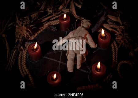 Occultist dripping hot wax on voodoo doll, magic rituals, black spell ...