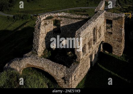 Repaired rubble walls cast long dark early evening shadows as the sun sinks to the west of the upper courtyard at Spiš Castle, a formidable medieval fortress built by Hungarian kings that stands on a 200m-high limestone spur in the Košice Region of eastern Slovakia.  The stronghold has survived sieges by invading Tartars and rival warlords as well as centuries of neglect and stone robbing. Stock Photo