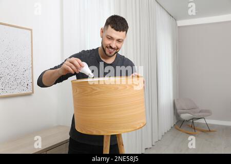Man changing light bulb in lamp at home Stock Photo