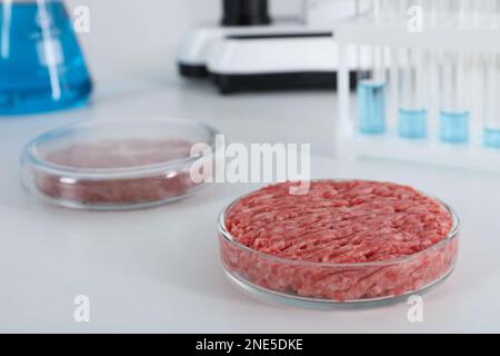 Petri dish with raw minced cultured meat on white table in laboratory, space for text Stock Photo