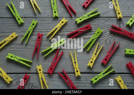 Colorful plastic clothespins on grey wooden background, flat lay Stock Photo