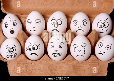 eggs painted with faces in an egg carton Stock Photo