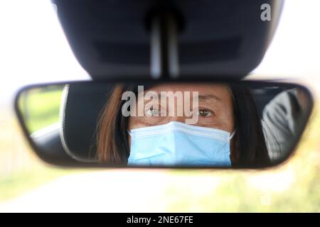 woman with protective mask driving a car Stock Photo