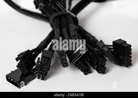 Bundled black modular power supply unit cables set, psu cords put together isolated on white. Modern pc assembly parts. Cable management concept. Clos Stock Photo