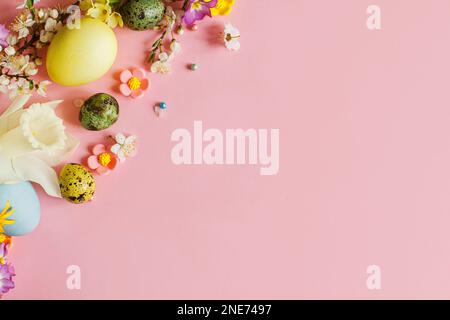 Happy Easter! Easter stylish eggs and blooming spring flowers on pink background, space for text. Modern greeting card or banner. Natural painted colo Stock Photo