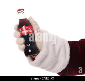 MYKOLAIV, UKRAINE - JANUARY 18, 2021: Santa Claus holding Coca-Cola bottle in hand on white background, closeup Stock Photo