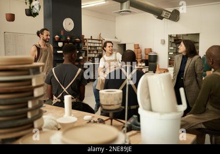 Diverse ceramics studio team talking during a meeting together Stock Photo