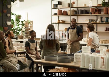 Diverse group of ceramics workers meeting together in a studio Stock Photo