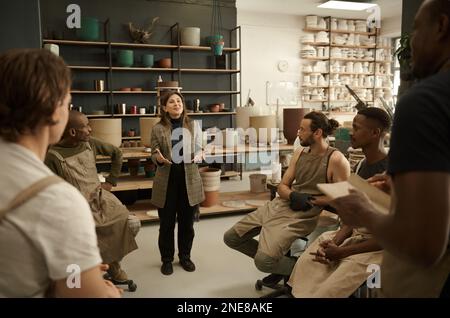 Smiling manager talking with her design team in a ceramics studio Stock Photo