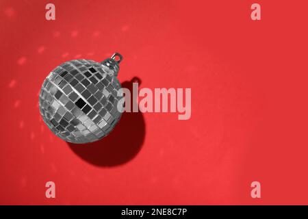 Bright shiny disco ball on red background, top view. Space for text Stock Photo