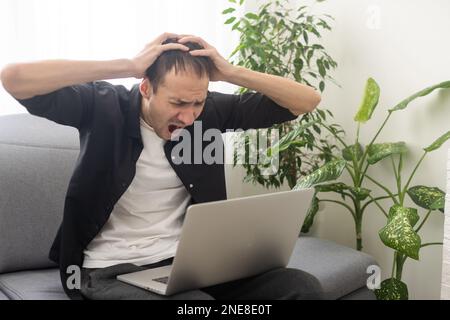 Happy smiling deaf young caucasian man uses sign language while video call using laptop while sitting at home, virtual communication concept. Stock Photo