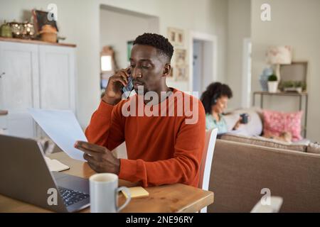 African man on a call while working remotely online from home Stock Photo