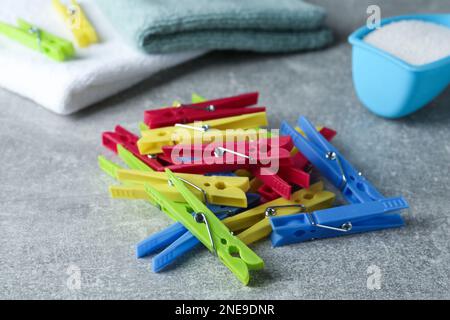 Colorful plastic clothespins on grey table, closeup Stock Photo